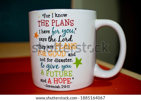 Bible verse Jeremiah 29:11 printed in colorful font on a white ceramic mug isolated on orange table mat. This is a popular verse among Christians.