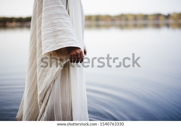 A biblical scene - of Jesus Christ\
walking in the water with a blurred\
background