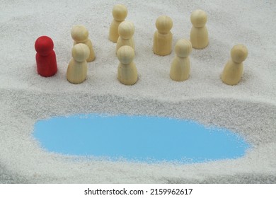 The biblical story Moses leads the Jews through the desert. Wooden people figures with leader on sand background with copy space for text.