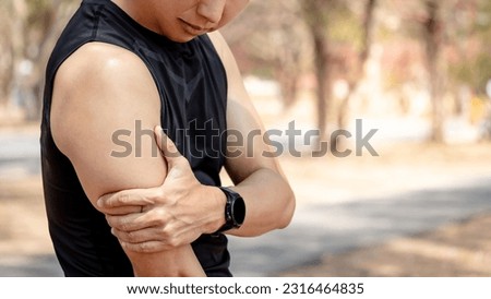 Bicep tendonitis or front arm muscle inflammation. Asian athlete man suffering from upper arm pain while doing outdoor exercise in the park. Sport injury concept
