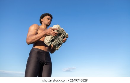 Biceps Exercise. Strong Guy Holding A Rock Doing Bicep Curls.