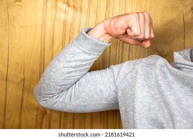 The Biceps on the arm. Athlete in hoodie.Muscles of the hand. Sportsman in a sweatshirt. Show arm muscle in a sweater.