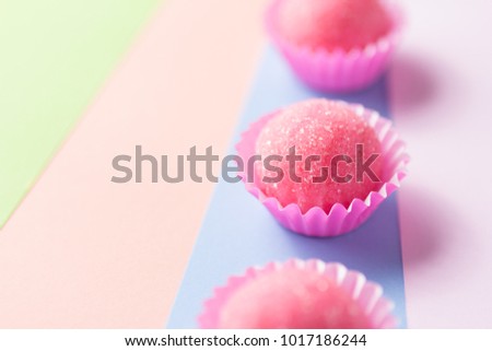 Bicho de pe is a strawberry flovoured brazilian candy. Common in children birthday parties sweet. Candy balls in a straight line. Colorful background.