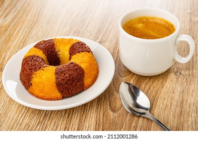 Bicolor Muffin In Shape Ring In White Glass Saucer, Cup With Coffee Espresso, Spoon On Wooden Table. Top View