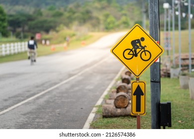 Bicycle or Bike lane traffic icon symbol with a people riding as blurred background. Sign and symbol for sport and recreation activity.