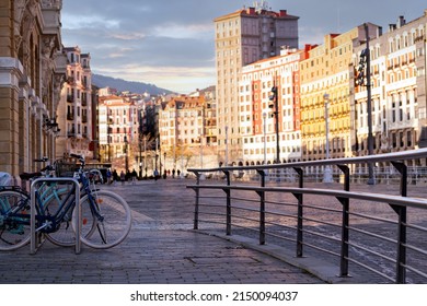 Bicycle At Bike Station For Travel Or Transport In Europe City. Sustainable Travel. Bicycle Sharing System. Bicycle Parked At Station On Blur People And Old Building In Spain. Eco-friendly Transport.