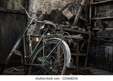 Bicycle in a dirty warehouse. An old bicycle in a dirty and dark warehouse. - Powered by Shutterstock