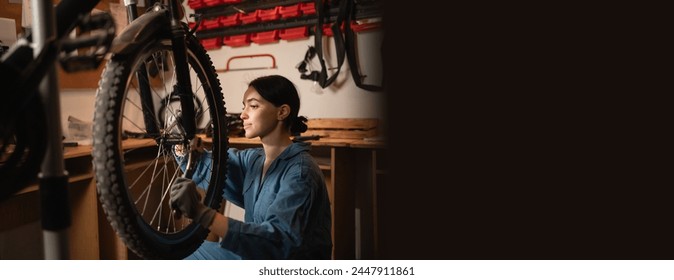 Bicycle female mechanic repairing bicycle doing his professional work in workshop or garage. Copy space - Powered by Shutterstock