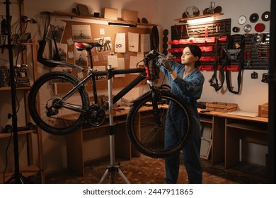 Bicycle female mechanic repairing bicycle doing his professional work in workshop or garage. Copy space - Powered by Shutterstock