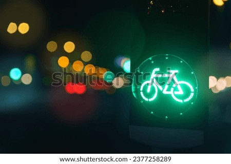 Bicycle green allowing lamp sign on traffic light road highway driveway drive crossroad intersection evening dark time german city. Bike forward movement safe on semaphore signal city street
