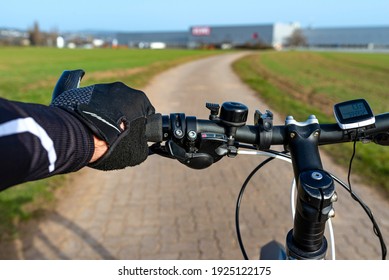 A Bicycle Handlebar Seen From The First Person Perspective And With A Mans Hand On The Handle. Visible Bike Computer And Bell.