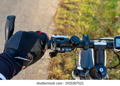 A Bicycle Handlebar Seen From The First Person Perspective And With A Mans Hand On The Handle. Visible Bike Computer And Bell.