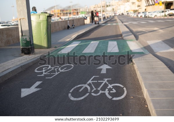 bicycle lane Dedicated\
of separate for move cyclists on road in city. Arrows show movement\
in one and other directions. sign on road ensures safety of\
people\'s lives