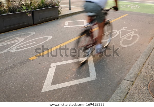 Bicycle Lane, Downtown Vancouver. A cyclist\
approaching an intersection using a designated bicycle lane which\
is separated from vehicle traffic in downtown Vancouver, British\
Columbia, Canada.