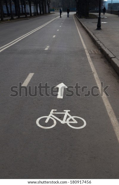 bicycle\
lane sign painted in white paint on gray\
asphalt
