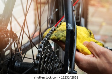 bicycle maintenance and repair - cleaning and oiling mountain bike chain and gear with oil spray