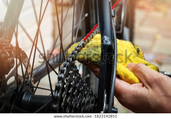 bicycle maintenance and repair -\
cleaning and oiling mountain bike chain and gear with oil\
spray