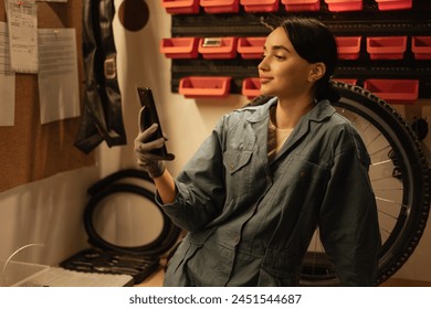 Bicycle mechanic working in a garage or workshop taking a selfie using his smartphone. Copy space - Powered by Shutterstock