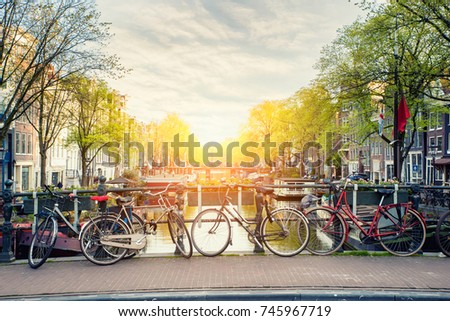Bicycle on the bridge with Netherlands traditional houses and Amsterdam canal in Amsterdam ,Netherlands. Landscape and nature travel, or historical building and sightseeing concept