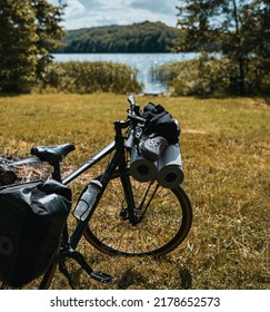 The bicycle is packed with many bags and other equipment ready for adventure and travel. Tourism on a mountain bike. Bike packing adventures in the woods and on the lakes. Baggage rack on the bike. - Shutterstock ID 2178652573