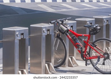 A bicycle parked between spaces of automatic vending bicycle parking machines on sidewalk of city street, unsafe parking concept