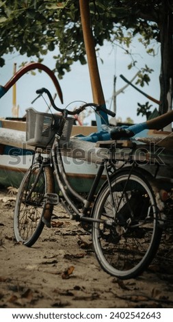 a bicycle parked next to a boat on the beach