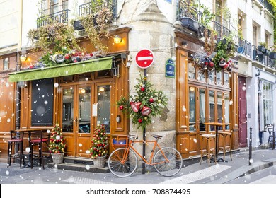 Bicycle is parked at typical Parisian cafes decorated for Christmas holidays in Paris, France