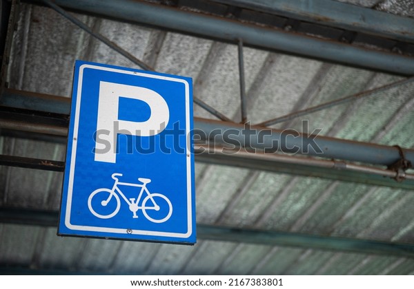 Bicycle parking lot reservation sign which is\
installed on the parking ceiling structure. Transportation and\
traffic symbol object\
photo.