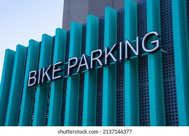 The bicycle parking sign is attached to the turquoise vertical elements of the exterior of the house. The designation of the bicycle storage and parking area.