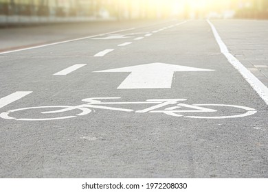 Bicycle path. Cycling transportation infrastructure. White bicycle lane sign on asphalt surface, safety zone. Selective focus - Shutterstock ID 1972208030