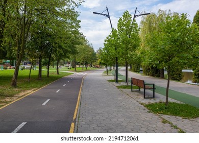 Bicycle Path, Jogging Path And Pedestrian Alley In The City Park On The Lake On A Summer Day