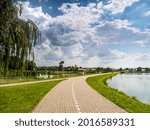 bicycle path running between two lakes against the backdrop of white clouds