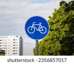 Bicycle path traffic sign in Germany. Close up of the cycle icon on a blue background. The symbol indicates a dedicated way or lane for cyclists next to a road.