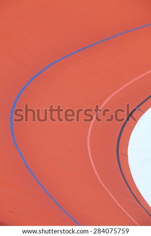 Bicycle racer flying around a curve in bicycle racing velodrome.