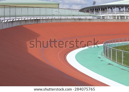 Bicycle racer flying around a curve in bicycle racing velodrome.