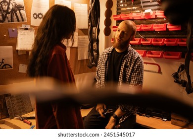 Bicycle repair in the garage. Colleagues or friends talking about a broken bicycle part. Copy space - Powered by Shutterstock