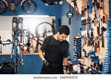 Bicycle repair, maintenance and tools with man in workshop for frame building or professional engineering. Assessment, bike and equipment with mechanic or technician in startup for restoration - Powered by Shutterstock