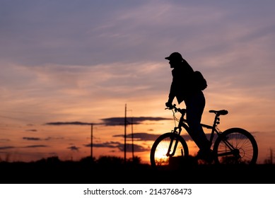 Bicycle Rider Silhouette With Sunset Sky In Background, Girl Riding Her Bike Staring At The Sunny Evening Sky