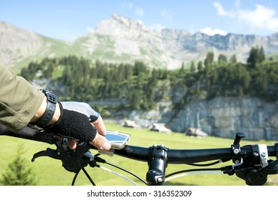 Bicycle Rider Uses His Smart Phone To Navigate In The Alps.