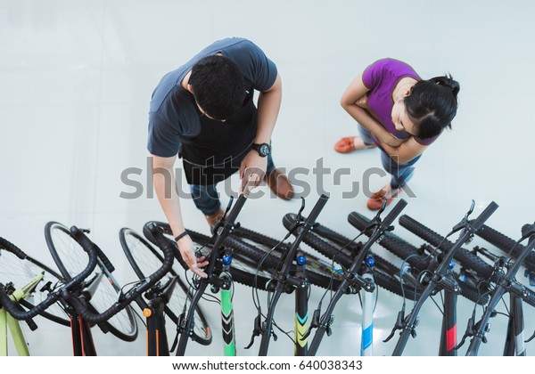 Bicycle salesman Helping customers buy a bike in a\
shop.top view 