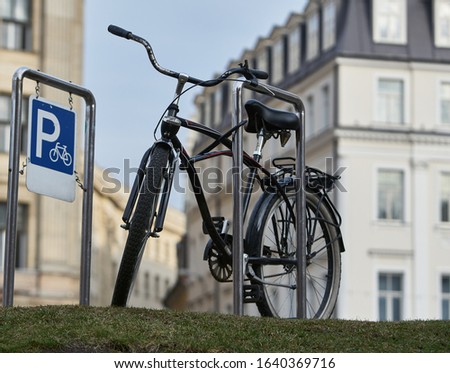 Bicycle secured on a parking in a city.