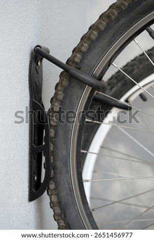 A bicycle is securely mounted on a wall with a strong holder designed for easy storage and organization. This setup saves space and keeps the bike accessible in a home setting.