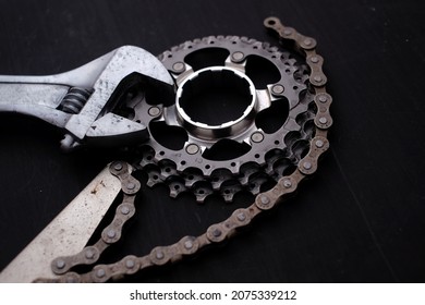 Bicycle Service And Maintenance Equipment. Adjustable Spanner, Chain Whip Tool And Bike Sprocket Isolated Black Background.