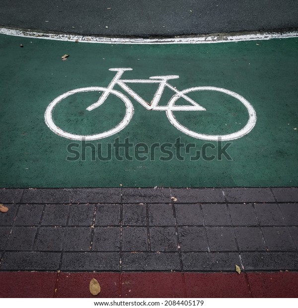 Bicycle sign separating\
city pedestrians. Exercise and recreation in urban parks. Bike lane\
and pavement.