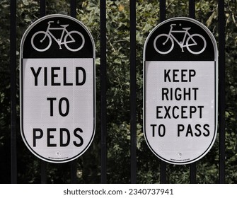 bicycle sign (yield to peds and keep right except to pass) on a fence by the entrance to the george washington bridge (gwb) in manhattan, new york city (cycling, biking, riding, bike, road cycle path)