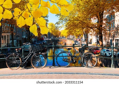 Bicycle Standing Next To Canal In Amsterdam, Fall In Netherlands