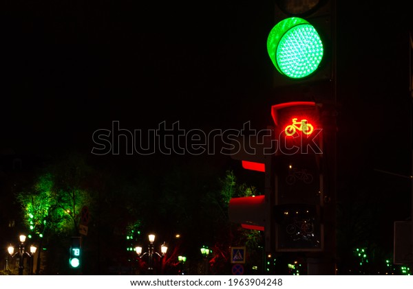 Bicycle traffic lights in Moscow. Green signal for\
cars, red signal for cyclists. Streetlights and traffic lights in\
the night.