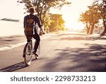 Bicycle, transport and back of man in road with lens flare for exercise, commute and cycling in morning. Travel, city and male cyclist on bike for eco friendly traveling, carbon footprint and journey