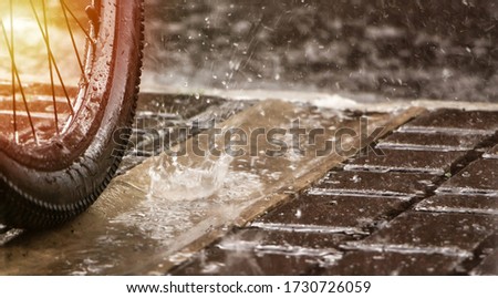 Bicycle wheel in the rain. Spray and raindrops. The rainy season for cyclists.