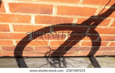 bicycle wheel with shadow reflection on brick wall